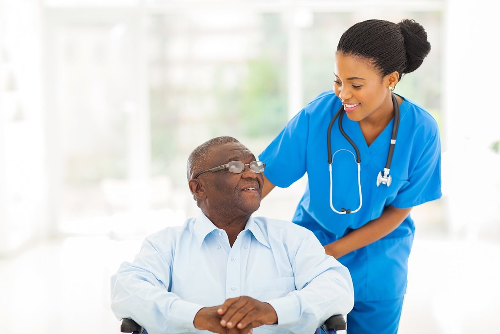 a nurse holding an elderly woman's hand