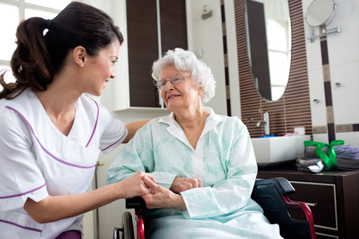a nurse holding an elderly woman's hand